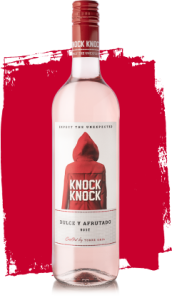 Copa llena de vino rosado dulce de KNOCK KNOCK, capturando la luz del sol.